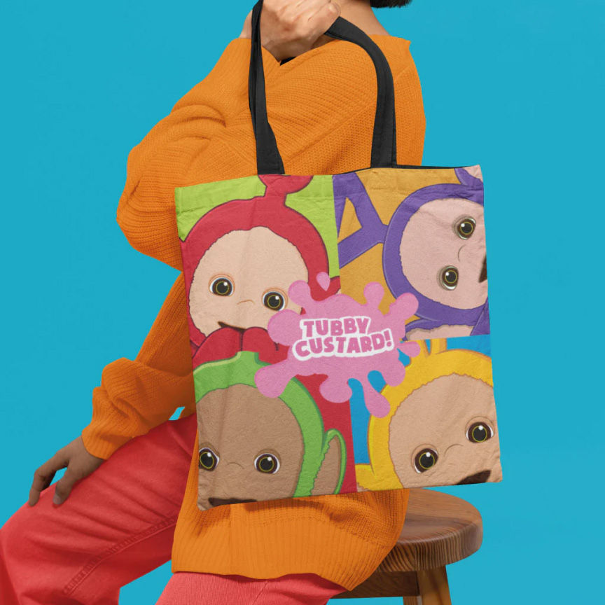 model in an orange sweater and red pants holding a colourful tote bag with Teletubbies