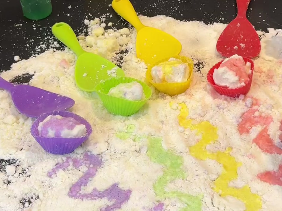 Laa-Laa and Po, the yellow and red Teletubbies, play outside in the snow.