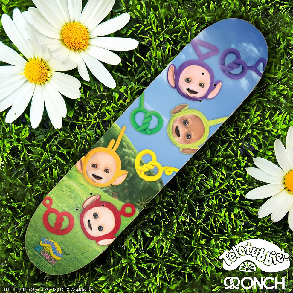 Skateboard deck with colorful cartoon characters on a green grass background with white daisies