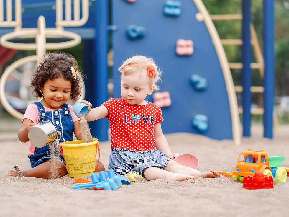 two children playing in the sand at a playground