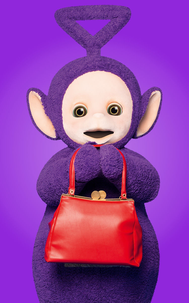 The purple Teletubby Tinky Winky with a triangular antenna holding a red bag