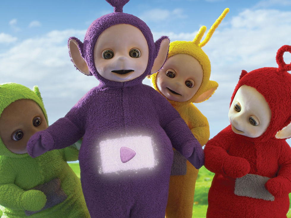 Tinky Winky the purple Teletubby with a video screen on its tummy, with other Teletubbies looking at it
